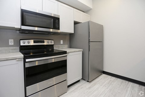 a kitchen with stainless steel appliances and a refrigerator